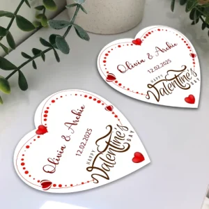 Pair of personalised wooden heart coasters featuring custom names and a non-slip cork base on a modern coffee table.